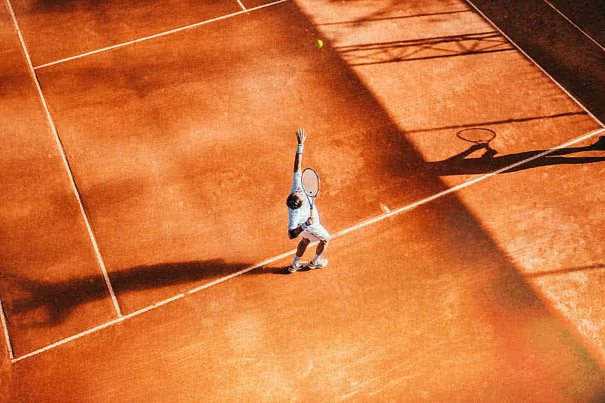 Tennisspieler beim Aufschlag im Sporthotel Sonnen Resort in Südtirol