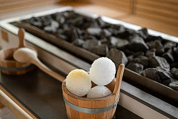 Nahaufnahme von Eiskugeln und Kohle für einen Saunaaufguss in einer Sauna im Sonnen Resort in Südtirol.