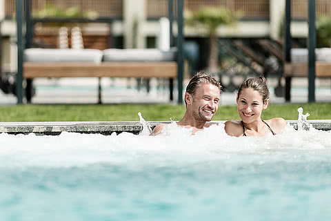 Paar entspannt im Outdoor Pool im Wellnesshotel Sonnen Resort in Südtirol